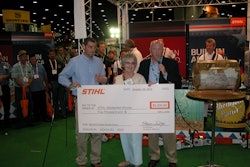 Mary Alice Gibson receives her $5,000 check from Stihl president Fred Whyte (left).