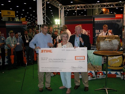 Mary Alice Gibson receives her $5,000 check from Stihl president Fred Whyte (left).