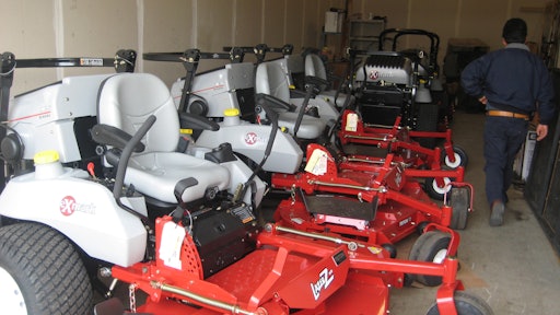 Photo of a landscape maintenance contractor's fleet of riding mowers in storage.