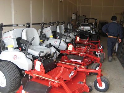 Photo of a landscape maintenance contractor's fleet of riding mowers in storage.
