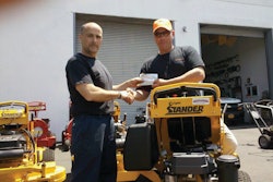 Artie D'Ambra (left) presents a $500 AMEX gift check to customer Peter Guido of PKG Gardens for the 500th Wright mower sold.