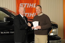 Marty Catron (right) accepts his plane tickets from Stihl Inc. president Fred Whyte (left).