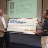 Abe Hughes, New Holland vice president of North America, presents the Fisher House Foundation with a check for $68,500.