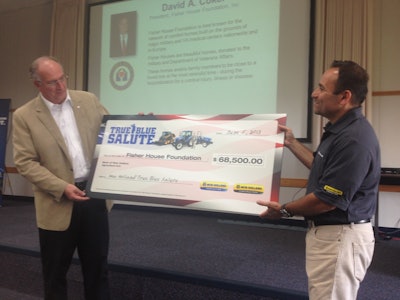 Abe Hughes, New Holland vice president of North America, presents the Fisher House Foundation with a check for $68,500.