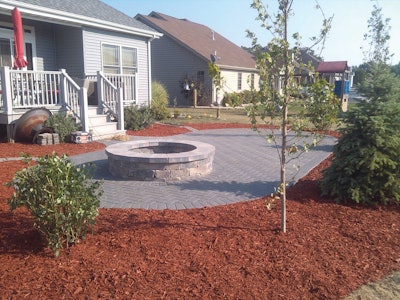 A completed paver patio with fire pit installed by Creekside Landscaping in Northwest Indiana.