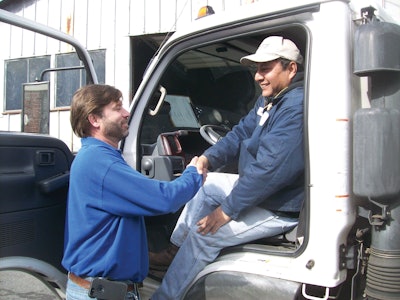 Derek Kelly (left) greets one of his maintenance division's crew leaders.
