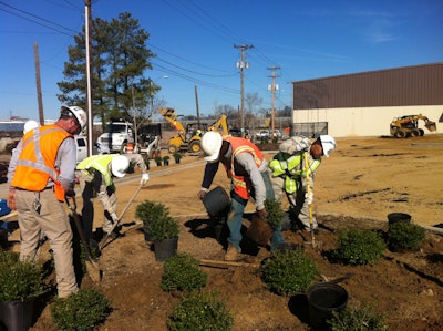 YouthBuild students work with the Michael Hatcher & Associates install crew on a landscaping project at a health center.