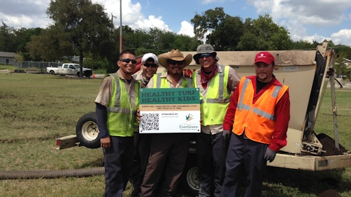 Some of the more than two dozen volunteers for the “Healthy Turf. Healthy Kids.” project take a break from renovating West End Park in San Antonio.
