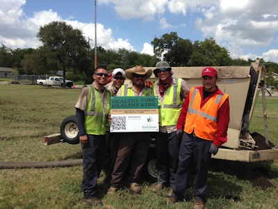 Some of the more than two dozen volunteers for the “Healthy Turf. Healthy Kids.” project take a break from renovating West End Park in San Antonio.