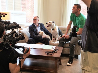 From Left: Kris Kiser; rescue dog Dottie; Lucky the TurfMutt, and Brandon McMillan of Lucky Dog discuss the new episode with the production team.