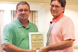 Mark Smith (striped shirt), Rotary’s vice president of sales and marketing, presents award to Kenny Purvis.