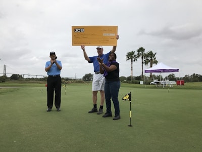 Arjun Mirdha, JCB North America President & CEO, and Tony Whitehurst, General Manager of JCB Finance, present Tammy Mixon, Executive Director of Wesley Community Centers, with a check for $90,000.