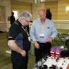 Erik Sides, executive director of the EETC (right), talks with a conference attendee about some of the association’s new training aids for educators.