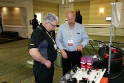 Erik Sides, executive director of the EETC (right), talks with a conference attendee about some of the association’s new training aids for educators.