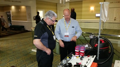 Erik Sides, executive director of the EETC (right), talks with a conference attendee about some of the association’s new training aids for educators.