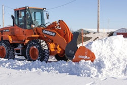 Make sure snow pusher attachments interfacing with a bucket are properly secured prior to use.