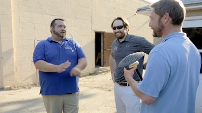 Art Ditzel, Kyle Davis and Phi MeGown discuss the installation of a lighting fixture.