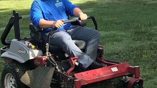 Christian Brown takes care of lawn on an Exmark mower.