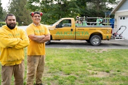 Members of the Augusta Lawn Care Services crew in uniform, in front of branded truck.