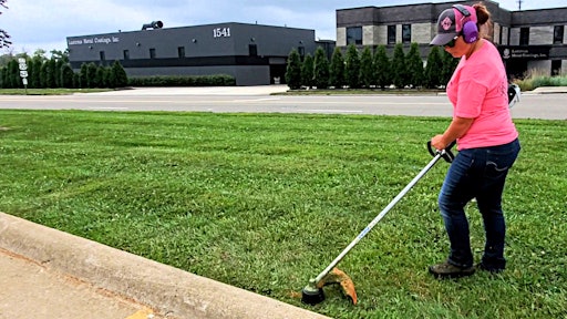 Savanaha Spencer (AKA 'TQ' or 'Trimming Queen') of Spencer Lawn Care doing trim work.
