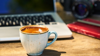 A Cup Of Coffee And A Camera On A Wooden Table In The 2347380