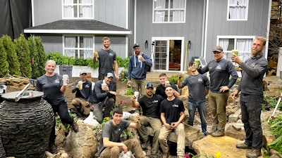 TEAM Aquascape and the Atlantis Water Gardens crew pictured in front of the Aquascape Sandbox Studio house façade built by Leader Builders.