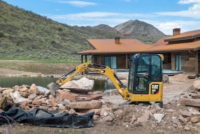 A Cat 302 CR makes short work of a retaining wall or pile of rock materials.