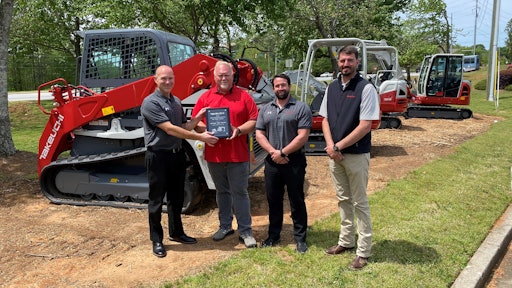 From left to right: John Vranches of Takeuchi presents Bill Smith of Cobb County Tractor with his award for being Takeuchi’s top dealer salesperson in 2020 while Takeuchi’s Steve DePriest and Austin Smith look on.