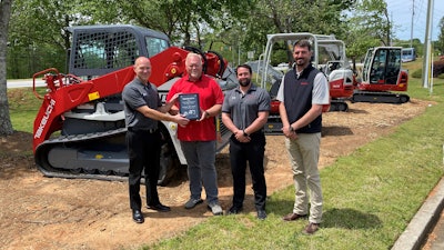 From left to right: John Vranches of Takeuchi presents Bill Smith of Cobb County Tractor with his award for being Takeuchi’s top dealer salesperson in 2020 while Takeuchi’s Steve DePriest and Austin Smith look on.