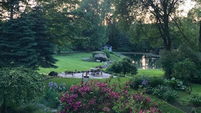 A Permeable Pennsylvania irregular bluestone patio sits above the wall, bordered by lavender.