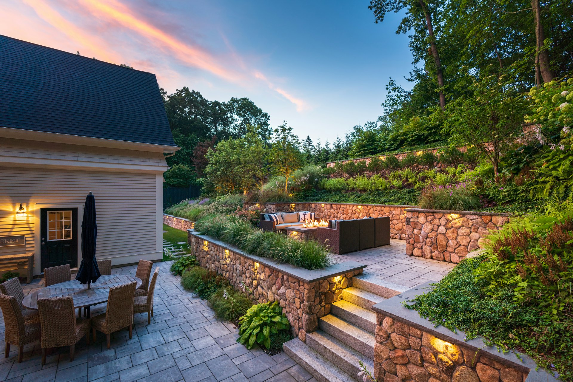 Multilevel terraced patios provided Lynch Landscape & Tree Service plenty of space to feature lush greenery and create usable entertainment space.
