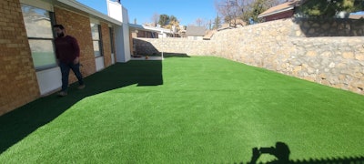 After the area was fully prepped, artificial grass was laid out onto the surface.
