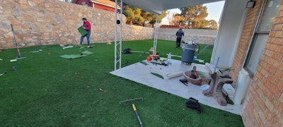 The crew installed artificial grass to the prepped surface of the backyard.