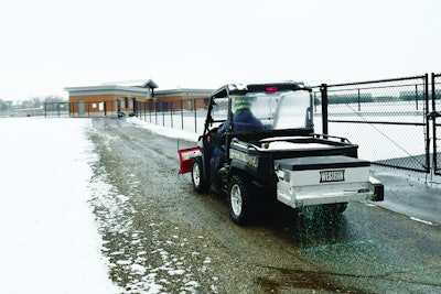 A drop spreader with a plow laying salt on a road is more efficient than three to four people on a shovel crew.