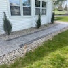 Archbold Landscaping laid natural stones around a recently installed walkway.