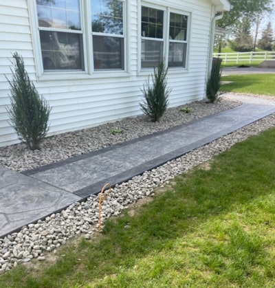 Archbold Landscaping laid natural stones around a recently installed walkway.
