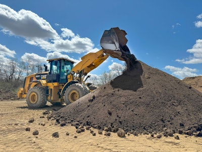 A CAT 950m wheel loader mixes topsoil for a custom blend.