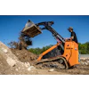 Construction skid-steer loader moving earth on a rocky work site