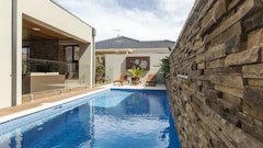 This multi-purpose backyard uses a stone veneer accent wall, featuring Cultured Stone’s Pro-Fit Alpine Ledgestone in Umber Creek, to introduce natural texture.