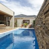 This multi-purpose backyard uses a stone veneer accent wall, featuring Cultured Stone’s Pro-Fit Alpine Ledgestone in Umber Creek, to introduce natural texture.
