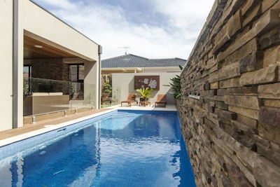 This multi-purpose backyard uses a stone veneer accent wall, featuring Cultured Stone’s Pro-Fit Alpine Ledgestone in Umber Creek, to introduce natural texture.