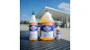 Three bottles of Lucas Oil Fuel Treatment displayed on a truck bed at a gas station with a canopy structure in the background