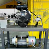 Industrial engine and air compressor equipment displayed on metal platform with technical specifications and Vanguard branding