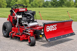 Red Ferris zero-turn mower with Boss snow plow attachment on asphalt driveway