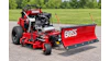 Red Ferris zero-turn mower with Boss snow plow attachment on asphalt driveway