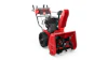 Red and black Toro two-stage snow blower with engine and chute on white background